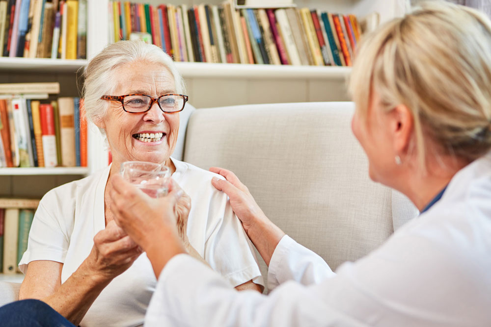 Nurse helps assisted living senior with meds