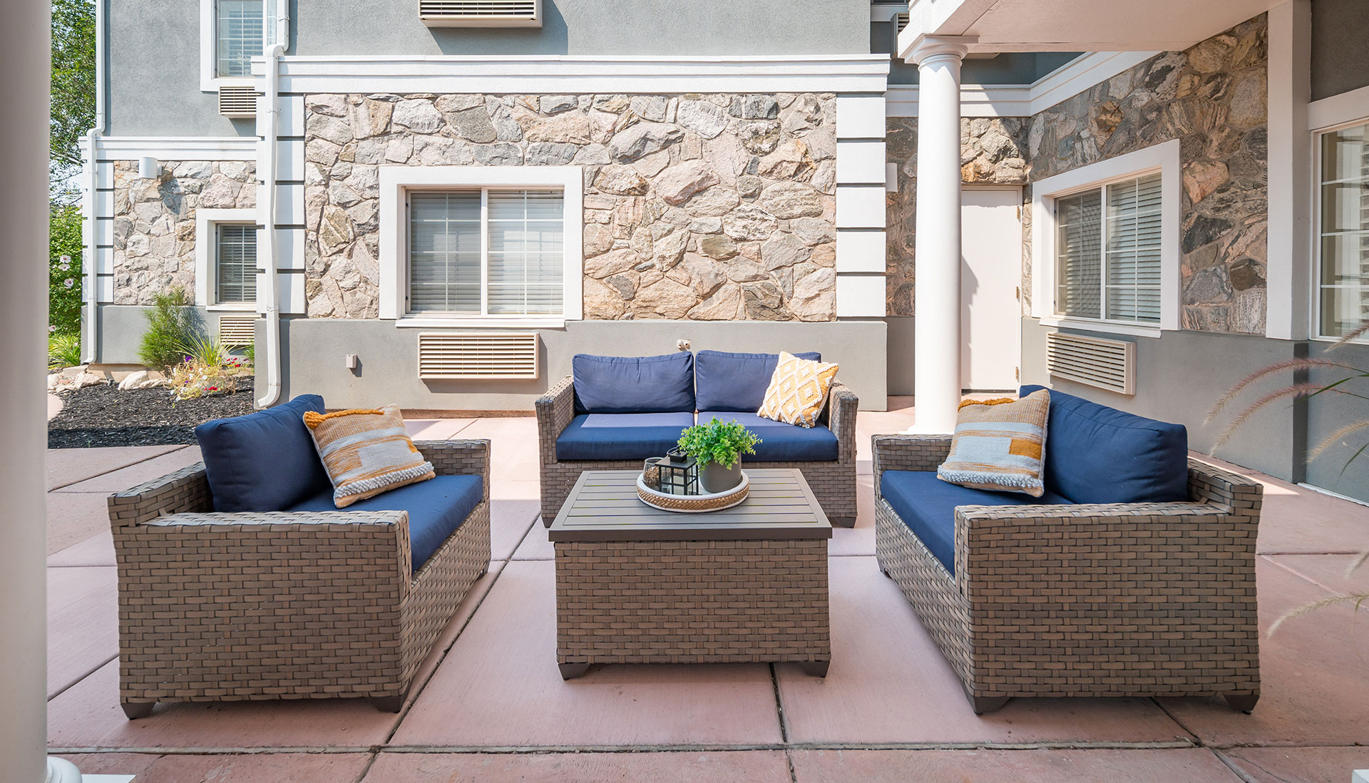 Outdoor patio area featuring comfortable seats and accent pillows