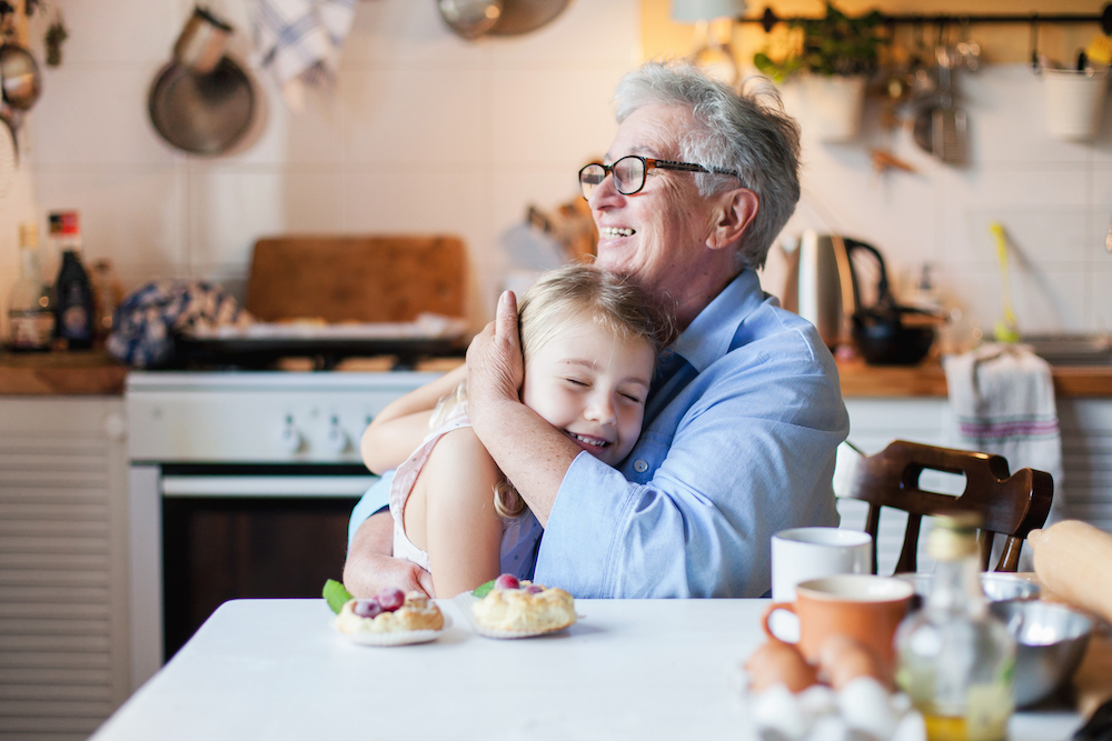 A senior woman and her granddaughter share a hug on Thanksgiving day